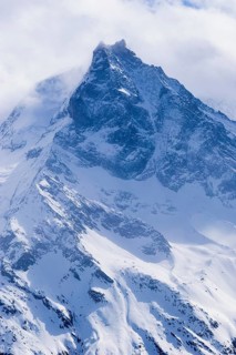 Fog envelops the snowy summit of the mountain Le Besso, Val d'Anniviers, Valais Alps, Canton