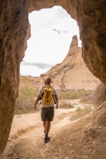 Vertical photo of a man walking along a path in the desert