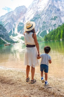 Mother and son admiring stunning panorama of lake braies, surrounded by majestic mountains and lush