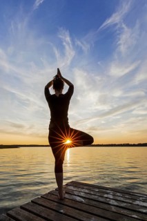 Woman practicing standing posture Vrikshasana, Tree Pose, one legged balancing asana of the