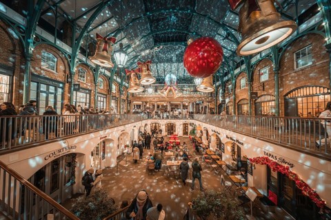 A festive interior with twinkling lights and two-level decoration full of people, AppleMarket,