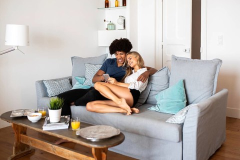 A happy couple sitting on a comfortable sofa, enjoying relaxed quality time together in a modern,