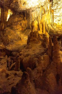 Stunning cave formations illuminated by warm lights, showcasing the beauty of nature's artistry in