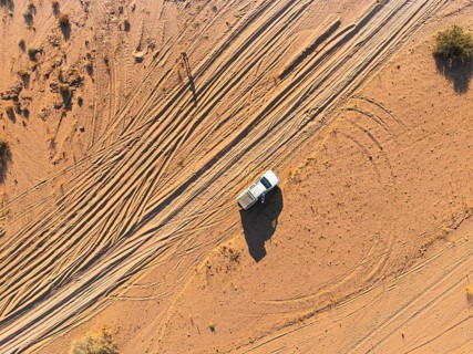 Aerial view, lonely road with offroad car, desert landscape, Erongo, Damaraland, Namibia