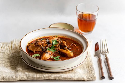 A bowl of traditional Georgian chicken stew, chakhokhbili, garnished with fresh coriander. This