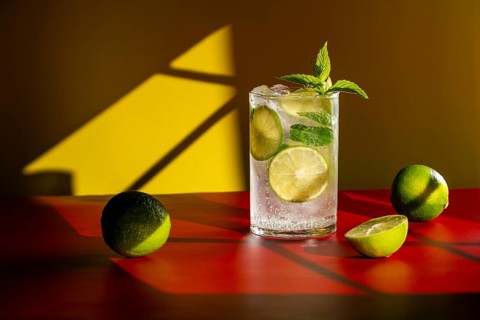 A refreshing classic mojito garnished with lime slices and mint leaves in a clear glass, set on a