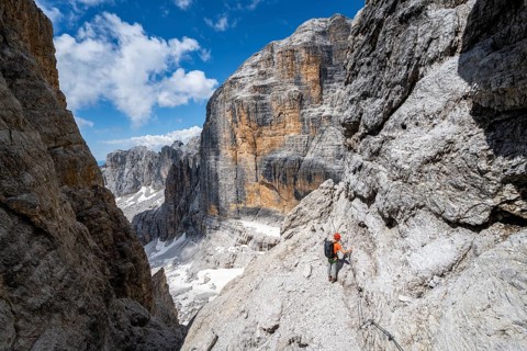 Climbers on the Via Ferrata Brentari via ferrata, spectacular mountain landscape with steep cliffs,