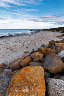Coastal defence, boulders with view on sandy beach, dusk, Carne Beach, Wexford, Gerrans Bay,