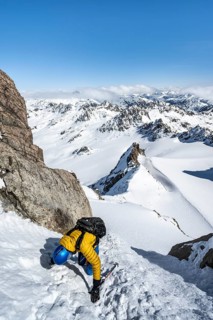 Mountaineer with ice axe and crampons, ascent through steep snowfield to Piz Kesch or Piz d'Es-cha
