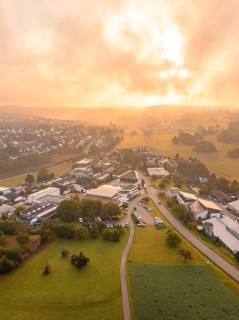 Wide panoramic view of a village at sunrise with green surroundings, Gechingen, Black Forest,