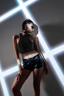 A stylish cyberpunk woman model in edgy fashion poses against a high-tech, modern backdrop. The