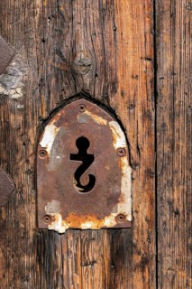Keyhole in the form of an upside-down question mark in the portal of the Chiesa SS. Giacomo e