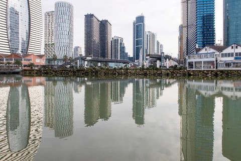 Batumi's modern skyscrapers reflect in the serene waters, highlighting the blend of contemporary
