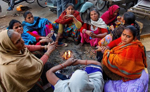 New Delhi, India, 15.01.10 - Women warm up by a fire at the market in New Delhi, India