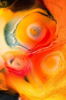 This abstract image features vibrant swirls of red, orange, and yellow hues, creating dynamic