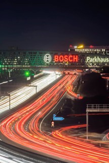 A8 motorway at Stuttgart Airport in the evening. Heavy traffic, lanes of light. Modern architecture