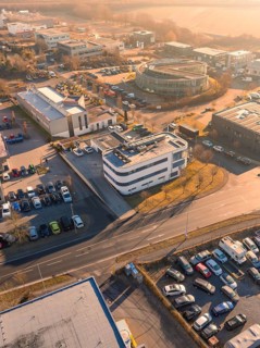 Aerial view of an urban industrial area with buildings and car parks under an orange sky,