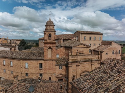 Historic buildings in Treia, Italy, showcase classic architecture with terracotta roofs under a