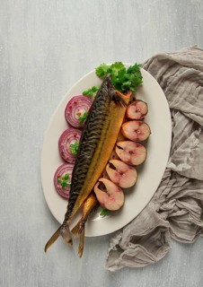 Smoked mackerel, top view, with spices, on a wooden table, no people, selective focus