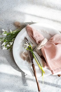 From above, an elegant spring-themed table setting featuring fresh snowdrops arranged on a white