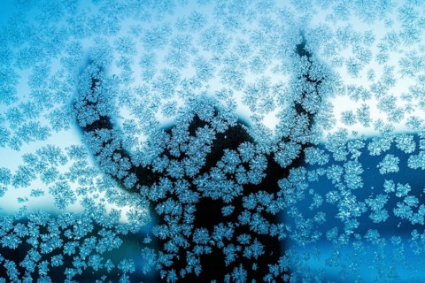 A captivating silhouette behind a frosty glass in Swedish Lapland, showcasing intricate ice crystal