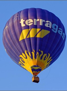A flying hot air balloon, inscription: terragas, Montgolfiade, yellow, blue, Austria