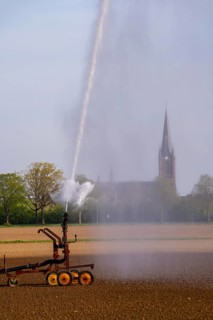 Artificial irrigation of a field, freshly sown, in April, with a sprinkler system, long drought in