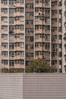 A close-up view of a densely packed residential building in Hong Kong, illustrating urban living