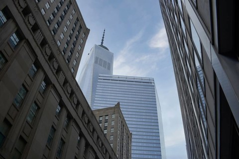 An upward angle captures the iconic silhouette of the One World Trade Center amid surrounding
