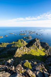 View of numerous small rocky islands with houses, at the summit of Festvågtind, view of