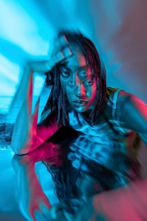 A futuristic portrait of a young African woman in a vibrant, digital metaverse. The image blends