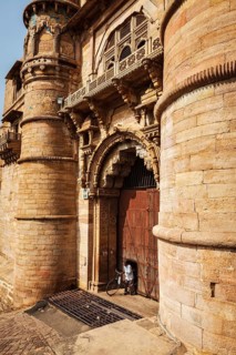 GWALIOR, INDIA, APRIL 11, 2011: Man with bicycle coming through door in huge gates of Gwalior Fort,