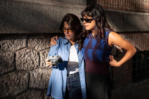 A multiethnic lesbian couple enjoys a moment together outdoors. One embracing the other while they