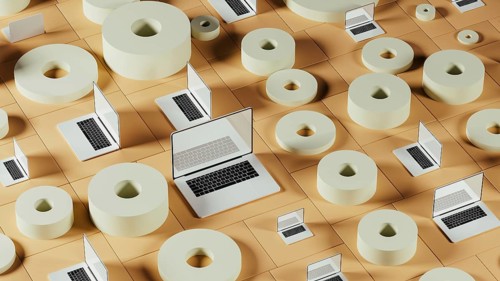 A collection of laptops placed among abstract geometric forms, showcasing a modern tech environment