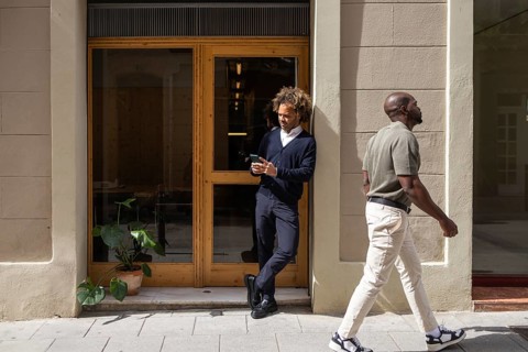 Professionals enjoying a sunny day outside a modern coworking space in Barcelona. The image