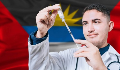 Doctor holding syringe on Antigua and Barbuda flag background. Medical professional holding syringe