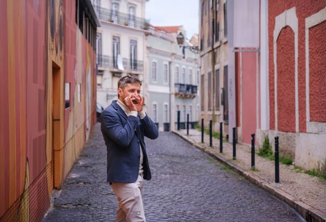 Man musician in a blue blazer and white sweater playing blues on a harmonica with eyes closed,
