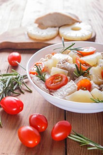 Chicken fillet salad with rosemary, pineapple and cherry tomatoes on brown wooden background. close