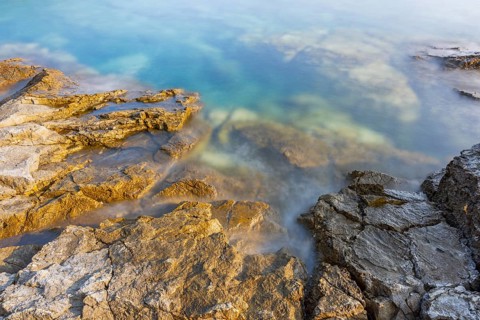 Crystal clear and turquoise water on the beach of Ustrine Bay on a sunny day on the island of Cres,
