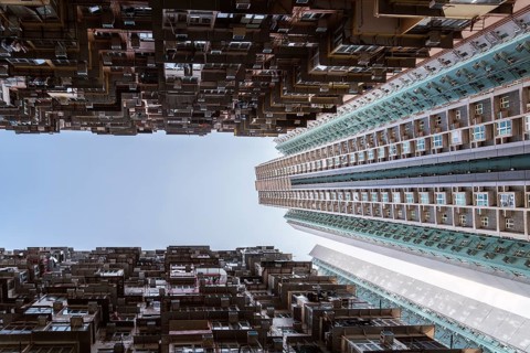 Low angle of a striking vertical view of dense residential towers in Hong Kong, showcasing the