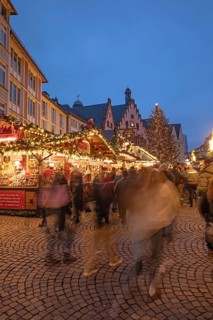 December 22, 2025, Frankfurt Christmas Market on Roemerberg at twilight. Traditional wooden stalls