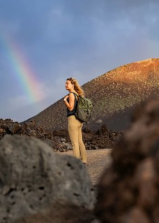 A woman with a backpack explores the volcanic landscape of Timanfaya National Park in Lanzarote. A