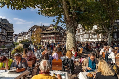 Busy cafe on Place Benjamin Zix and the Maison des Tanneurs timber-frame house in Petite France,