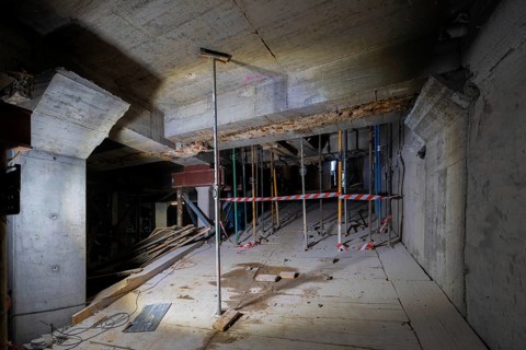 A detailed view of a construction site showing a partially completed structure. Wooden planks,