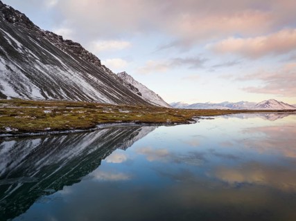 Breathtaking winter landscape of Iceland featuring snow-capped mountains and their reflection in