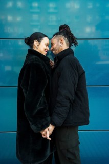 A multiethnic couple holds hands and shares a tender moment. This image symbolizes love,