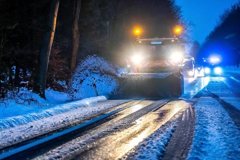 Winter service, spreader and snow plough in use, clears snow and slush from a regional road,