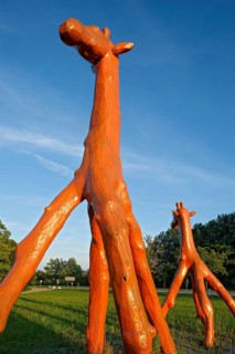 Giraffes made of red painted tree trunks, wooden sculpture by Günter Schumann, Museum of the