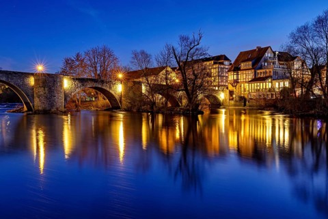 Illuminated bridge reflected in the blue water at night, peaceful atmosphere, The historic