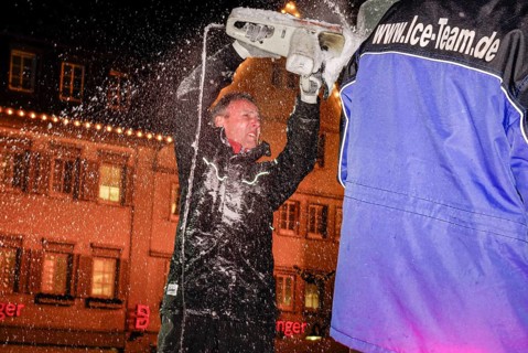 An ice sculpture is being created: ice carving street action as part of the long shopping night in